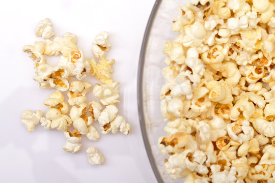 popcorn in glass bowl over white background