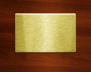 Blank golden plate at wooden background with copy space