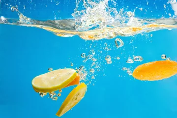 Foto op Canvas GELE citrusvruchten SPETTEN IN WATER © Natalya Glinskaya