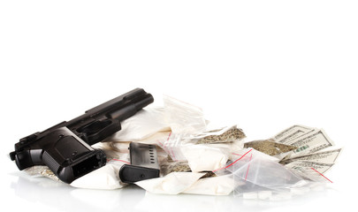 Cocaine and marijuana in packet with gun isolated on white