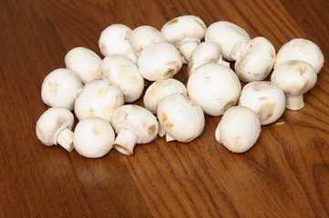 White freshs Paris mushrooms on wooden table for cooking.
