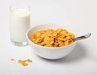 Corn flakes in deep plate with spoon and glass - Powered by Adobe