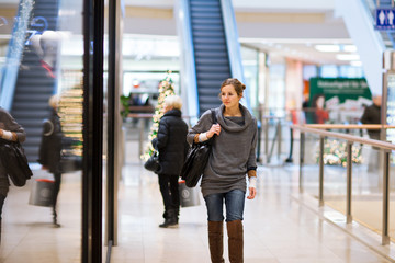 Young woman looking at store windows when shopping in a shopping