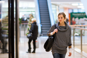 Young woman looking at store windows when shopping in a shopping