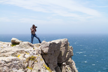Obraz premium african photographer taking photos on cliff