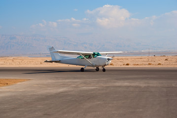 Fototapeta na wymiar Biały samolot Cessna-172 na lotnisku pustyni