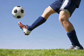 Athlete Kicking a soccer ball on field