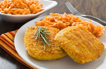 Chicken cordon bleu with grated carrots.