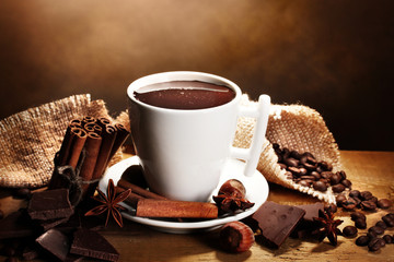 cup of hot chocolate, cinnamon sticks, nuts and chocolate