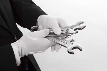 Schraubenschlüssel mit weißen Handschuhen anfassen - Serie wei