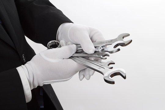 Schraubenschl&uuml;ssel mit wei&szlig;en Handschuhen anfassen - Serie wei