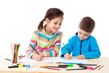 Two little kids draw with crayons
