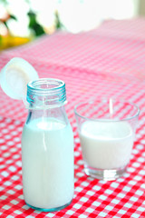 glass of milk and bottle on table