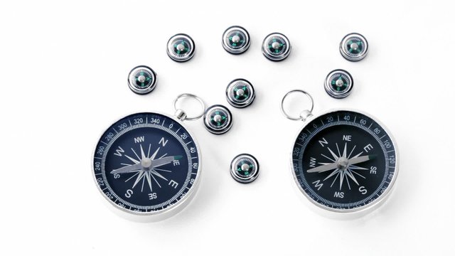 Nine small plastic compasses and two big isolated