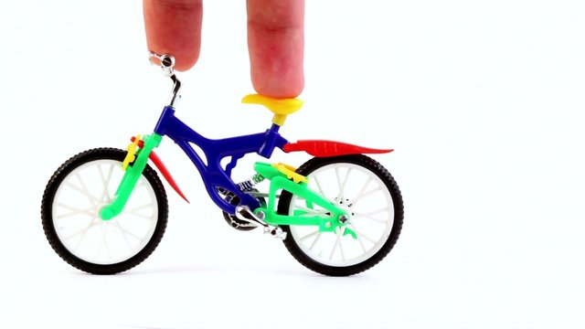 Fingers ride on toy bike, then press on it and moves away
