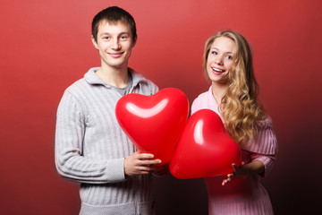 Fototapeta na wymiar Portrait of two young people holding heart-shaped balloon