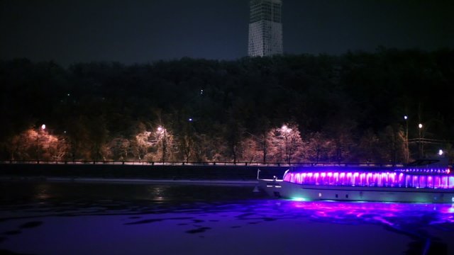 Motor ship decorated with garlands, floats down river