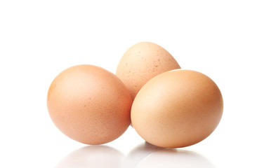 three brown eggs isolated on white