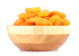 delicious dried apricots in wooden bowl isolated on white