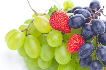 bunch of white and black grapes and strawberries isolated on whi