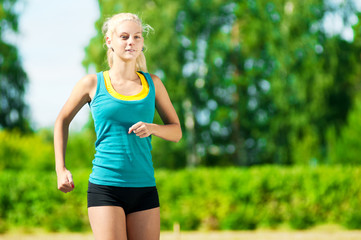 Young woman running in green park