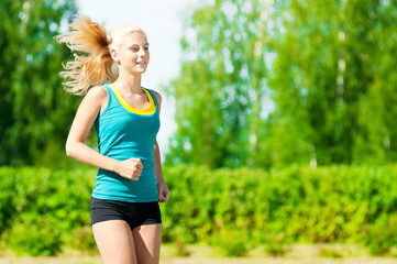 Young woman running in green park