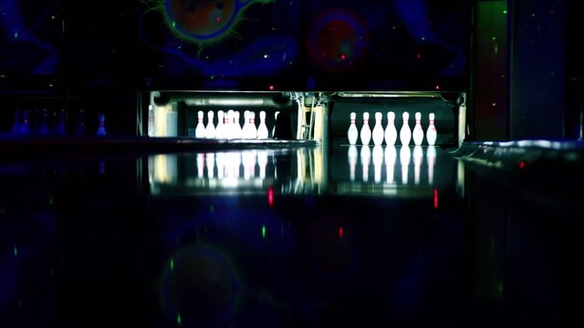 Machine set up tenpins at bowling lit in dark club