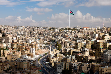 view of the city of Amman with Jordanian flags