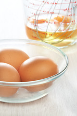 Fototapeta na wymiar Świeże jajka w misce i ubij z surowych jaj w miarce