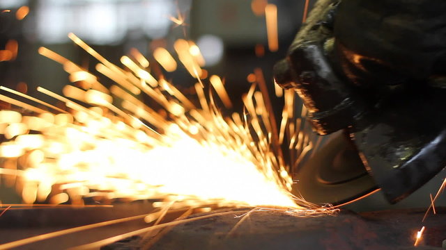 Men at work grinding steel