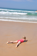 Kind liegt am  Strand