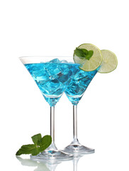 Blue cocktail in martini glasses with ice isolated on white