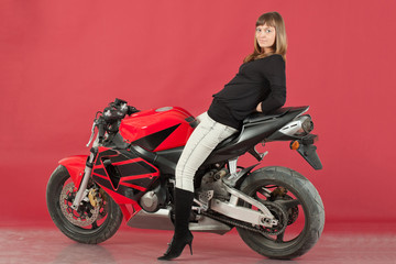 Fototapeta na wymiar Young girl with bike, on red background