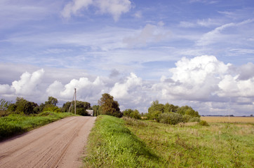 Fototapeta na wymiar Rural gravel road and house in distance