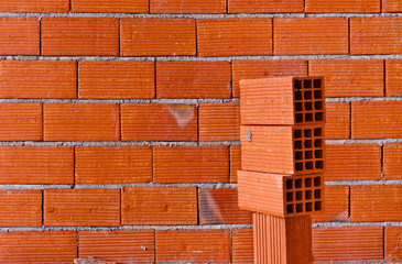 Brick wall with a stack of new bricks
