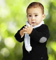 portrait of adorable kid clapping against a nature background
