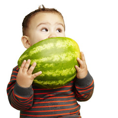 Fototapeta premium portrait of a handsome kid holding watermelon and sucking agains
