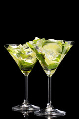glasses of cocktails with lime and mint on black background