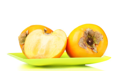 Appetizing persimmons on green plate isolated on white