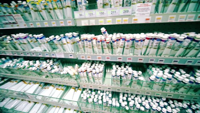 Many tubes of paint are on shelves in store