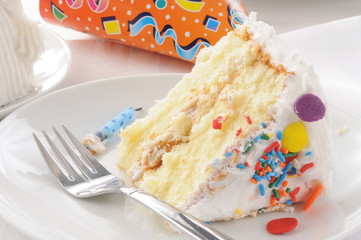 Slice of birthday cake and a party hat