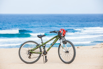 Obraz premium Bicycle with helmet, stand on the beach.