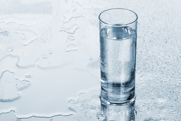 Glass of water on blue background