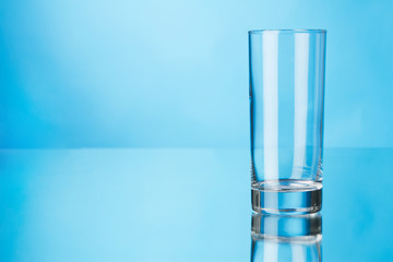 Empty glass on blue background