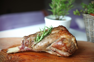 Roasted leg of lamb with rosemary on the cutting board - 38650346