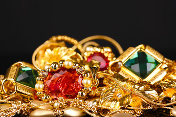 Various gold jewellery on black background