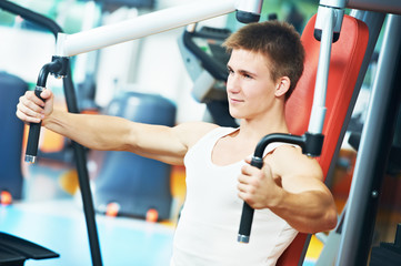 Fototapeta premium positive man at chest exercises machine