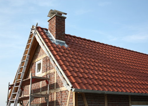 Neu eingedecktes Fachwerkhaus, mit Ger&uuml;st und Leiter, in Hamm-Bockum H&ouml;vel bei blauem Himmel.