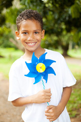 cute little boy holding a pinwheel outdoors