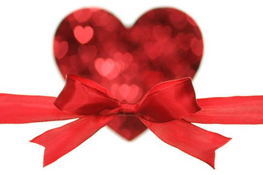 Red bow on heart shape by little heart.